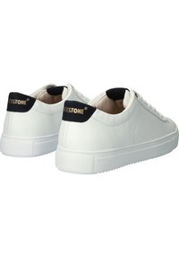 Sneaker in pelle bianca con texture liscia, dettagli blu navy sul tallone e suole in gomma bianca. Nome del marchio visibile sul tallone.