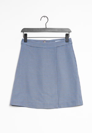 Falda de línea A con patrón de pata de gallo azul y marrón, con botones y cremallera en la parte delantera, colgada en una percha negra sobre un fondo blanco.