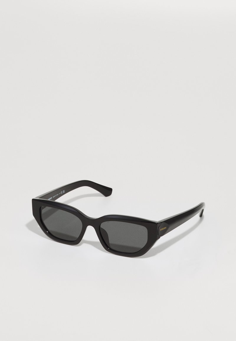Óculos de sol retangulares pretos com lentes escuras, armações de plástico espessas, frente com bordas angulares e acabamento ligeiramente brilhante. Detalhe em dourado na haste.