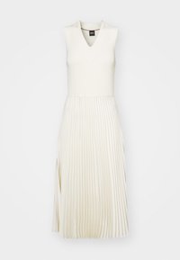 Robe crème sans manches avec haut à col en V et jupe midi plissée, avec une fente latérale et une texture côtelée sur la partie supérieure.