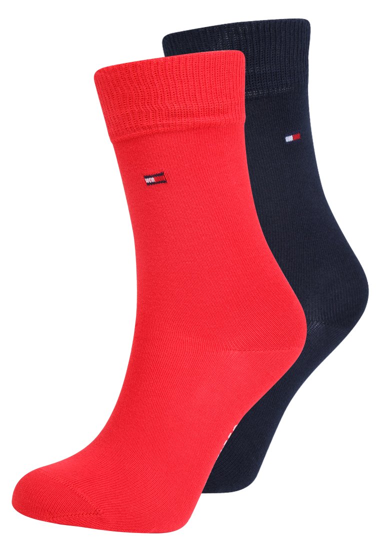 Chaussettes rouges et bleu marine en tissu tricoté lisse, avec des bords côtelés et un petit logo brodé sur chaque chaussette.