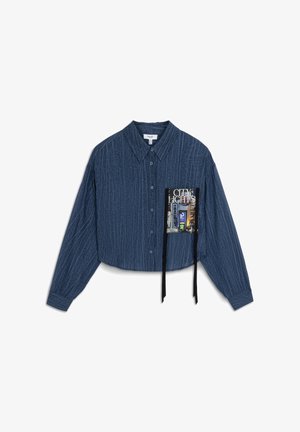 Cropped blue button-up shirt in textured fabric, featuring a front pocket with a graphic print and black drawstrings attached.