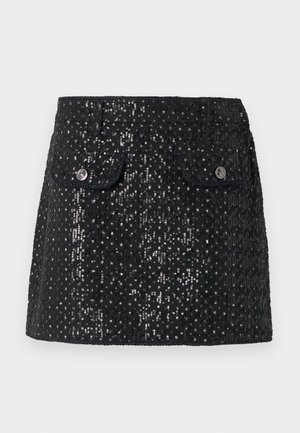 Μαύρη μίνι φούστα καλυμμένη με μικρές λαμπερές παγιέτες, με δύο εμπρόσθιες τσέπες με καπάκι, στερεωμένες με ασημένια κουμπιά.