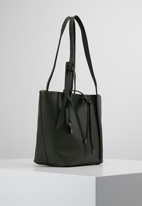 Borsa a secchiello in pelle verde con texture, due lunghe tracolle, chiusura superiore aperta con cordoncini e dettagli in metallo argentato.