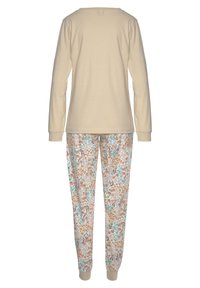 Camiseta de manga larga beige y pantalones de pijama con estampado floral. Los pantalones están hechos de una tela ligera con acentos florales en naranja, azul verdoso y verde.