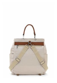 Beige Rucksack mit einem Stoffkörper, hellbraunem Leder-Tragegriff, verstellbaren Canvas-Trägern, silbernem Zubehör und einer vorderen Reißverschlusstasche.