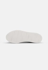 Flat, white rubber shoe sole with horizontal grooves and embossed branding. Smooth texture, rounded shape, designed for comfort and durability.