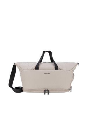 Sac rectangulaire souple beige clair avec poignées noires, bandoulière réglable, poche avant zippée et nom de la marque "BOGNER" à l'avant.