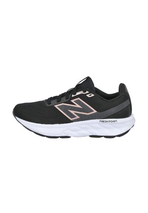 Zapatilla deportiva negra con parte superior de malla, acentos rosas, mediopie blanca acolchada y suela negra texturizada para mayor agarre. Presenta un logo en el lateral.