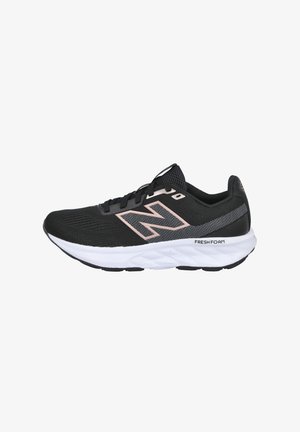 Zapatilla deportiva negra con parte superior de malla, acentos rosas, mediopie blanca acolchada y suela negra texturizada para mayor agarre. Presenta un logo en el lateral.