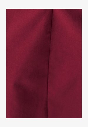 Bordeaux stof close-up met een gladde textuur en een subtiele glans, waarop een naaddetail langs één zijde zichtbaar is.