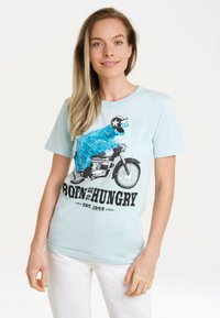 Hellblaues T-Shirt mit einem bunten Grafikmotiv eines pelzigen Charakters auf einem Motorrad, mit schwarzem Text "BORN TO BE HUNGRY".
