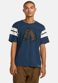 T-shirt bleu marine à manches courtes, arborant un graphique de cheval et des accents rayés blancs sur les manches, fabriqué en tissu doux en mélange de coton.