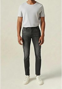 Jeans grigio scuro con design a vestibilità slim, abbinati a una t-shirt grigio chiaro e sneakers bianche. Tessuto liscio con classica struttura a cinque tasche.