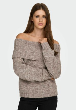 Off-the-shoulder ribstrikket trøje i lys beige. Blød tekstur med en løs pasform og lange ærmer. Hemmet afsluttes med en subtil flosset kant.