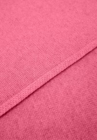 Roze gebreide stof met een gestructureerd patroon en een gladde rand. Het materiaal is zacht en heeft twee tinten roze.