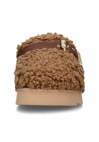 Zapatilla marrón difusa con una superficie texturizada, una correa de cuero marrón con una hebilla dorada y una suela robusta y de color claro.