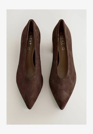 Hnedé semišové lodičky na vysokom opätku s ostrou špicou a širokým výrezom po stranách. Hladká textúra, minimalistický dizajn a bez viditeľného kovania.