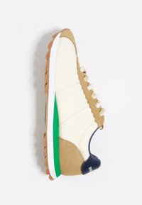 Zapatillas de ante y cuero, en tonos beige y crema con suela verde, talón azul oscuro contrastante y cordones blancos en un diseño de perfil bajo.