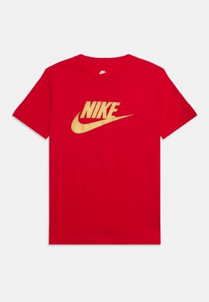 T-shirt Nike rouge à manches courtes, avec un grand logo Nike doré et le swoosh sur la poitrine.