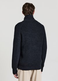 Maglione a coste grigio scuro con collo alto e maniche lunghe, caratterizzato da una superficie testurizzata e una vestibilità comoda. Vista posteriore mostrata.