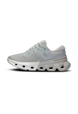 Zapatilla deportiva de color gris claro con parte superior de malla, acentos texturizados, cordones en la parte frontal y una suela gruesa y acolchada con orificios de ventilación.