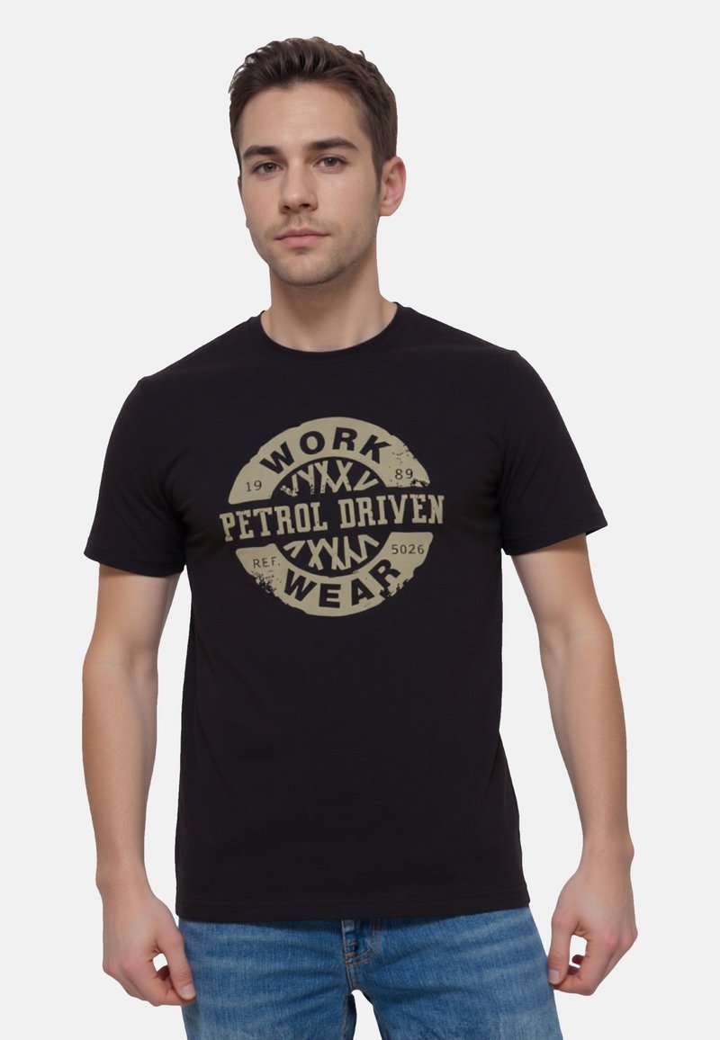 Czarny bawełniany t-shirt z wyraźnym beżowym nadrukiem graficznym z napisem "WORK PETROL DRIVEN WEAR" na środku, okrągły kształt z postarzanym detalem.