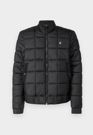 Black puffer jacket with a zippered front, ribbed collar, and quilted design. Features side pockets and a small logo on the chest.