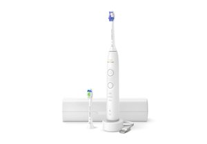 Brosse à dents électrique blanche avec deux têtes de rechange, socle de chargement, câble USB et étui de voyage fermé sur fond blanc.