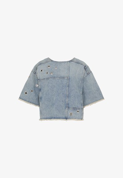 Veste en denim bleu clair courte avec manches courtes, bords effilochés et plusieurs œillets en métal argenté sur le dos et la manche.