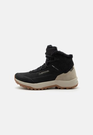 Black and beige winter hiking boot with fur lining, lace-up front, rugged sole, and visible LOWA and Gore-Tex logos on the side.