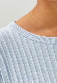 Maglione in maglia di un azzurro chiaro con texture a coste verticali, dotato di un ampio scollo rotondo e di un tessuto morbido.