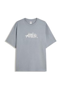 Grå bomulds T-shirt med afslappet pasform, der har hvid grafisk tekst i en styliseret skrifttype tværs over brystet og en ribbet rund hals.