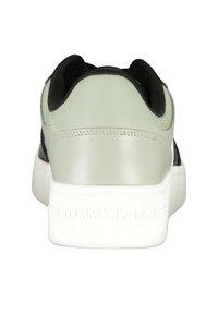 Roheline ja must toss, millel on sile nahast kanna, tekstureeritud külgpaneel ja valgest kummist tald. Kanna peal on "TOMMY JEANS" bränding.