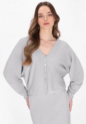 Hellgrauer, langärmeliger Cardigan mit V-Ausschnitt, ausgestattet mit sechs Knopfverschlüssen und einer weichen Textur. Lockere Passform und leicht verkürzter Schnitt.