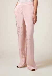 Pink satin trousers with a floral pattern, wide-leg design, side pockets, and a smooth texture, featuring a waistband.