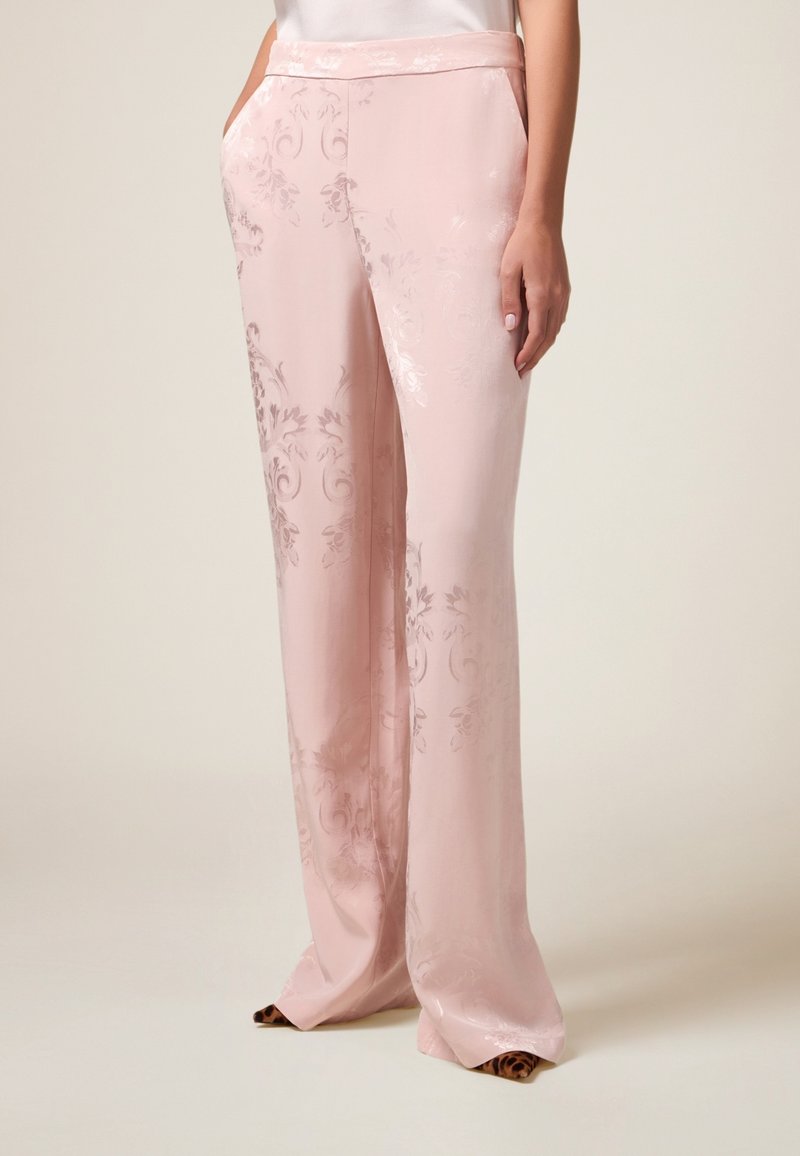 Pink satin trousers with a floral pattern, wide-leg design, side pockets, and a smooth texture, featuring a waistband.