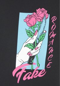 Black short-sleeve shirt featuring a graphic of a hand holding a knife and roses against a light blue rectangle, with "Fake Romance" in pink text.