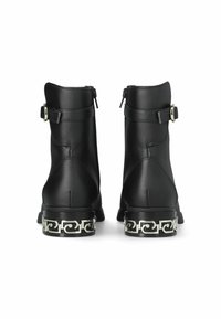 Stivali alla caviglia in pelle nera con una superficie liscia, dotati di cerniere laterali, una cintura regolabile e un tacco decorativo con motivo argentato.