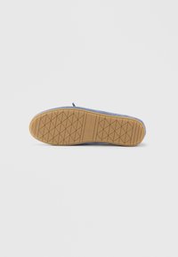 Calzature blu con suola in gomma testurizzata con motivo a diamante e tomaia in materiale morbido. Design minimale senza elementi metallici visibili.