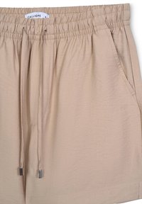 Pantaloni corti beige realizzati in tessuto leggero con vita elasticizzata, cordoncino e due tasche laterali. Texture liscia, design informale.