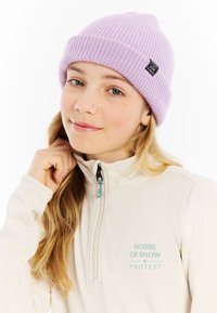 Lichtpaars gebreid beanie met een geribbeld textuur, voorzien van een klein zwart logo tag. Gekocht met een crèmekleurige fleece met ritssluiting.