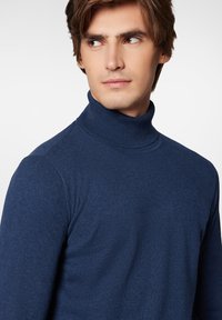 Granatowy sweter z golfem wykonany z miękkiej dzianiny, z dopasowanym krojem i prążkowanymi akcentami przy kołnierzu i mankietach.