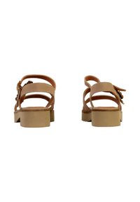 Sandali marroni con una texture liscia, dotati di tacco a blocco, più cinghie e decorazioni hardware sul lato.