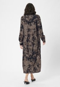 Rochie maxi cu mânecă lungă, în model abstract negru și maro. Confecționată dintr-un material ușor, cu o croială lejeră și talie gathered.