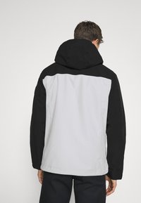 Černá a světle šedá bunda s kapucí a hladkou texturou, s kontrastními panely a uvolněným střihem, vhodná pro venkovní nošení.
