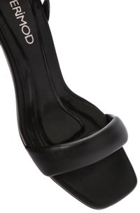 Sandale noire à talons avec un bout carré, dessus en cuir lisse, large bride avant et dos ouvert. Présente un design élégant et minimaliste.