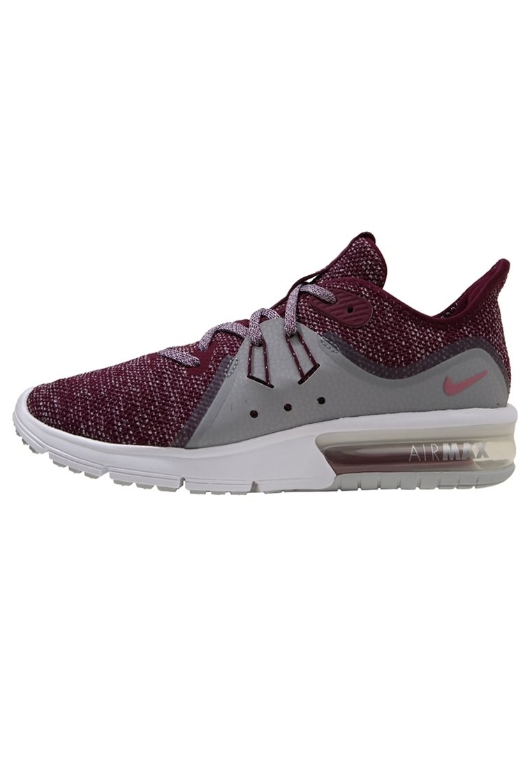 Baskets à tige tricotée violette avec des accents gris, une semelle intermédiaire blanche, une unité de coussin d'air proéminente et des lacets réfléchissants. Marque Nike sur le côté.