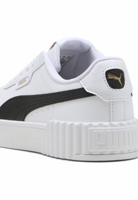 Tenis alb din piele cu o dungă neagră PUMA, talpă texturată albă, branding discret auriu și guler căptușit pentru confort.