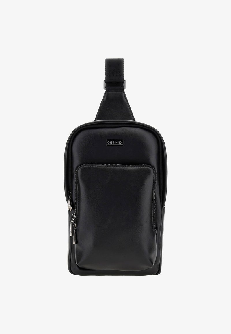 Sac en cuir noir de style bandoulière avec une texture lisse, de forme rectangulaire, poche à fermeture éclair à l'avant et logo embossé. Sangle ajustable incluse.